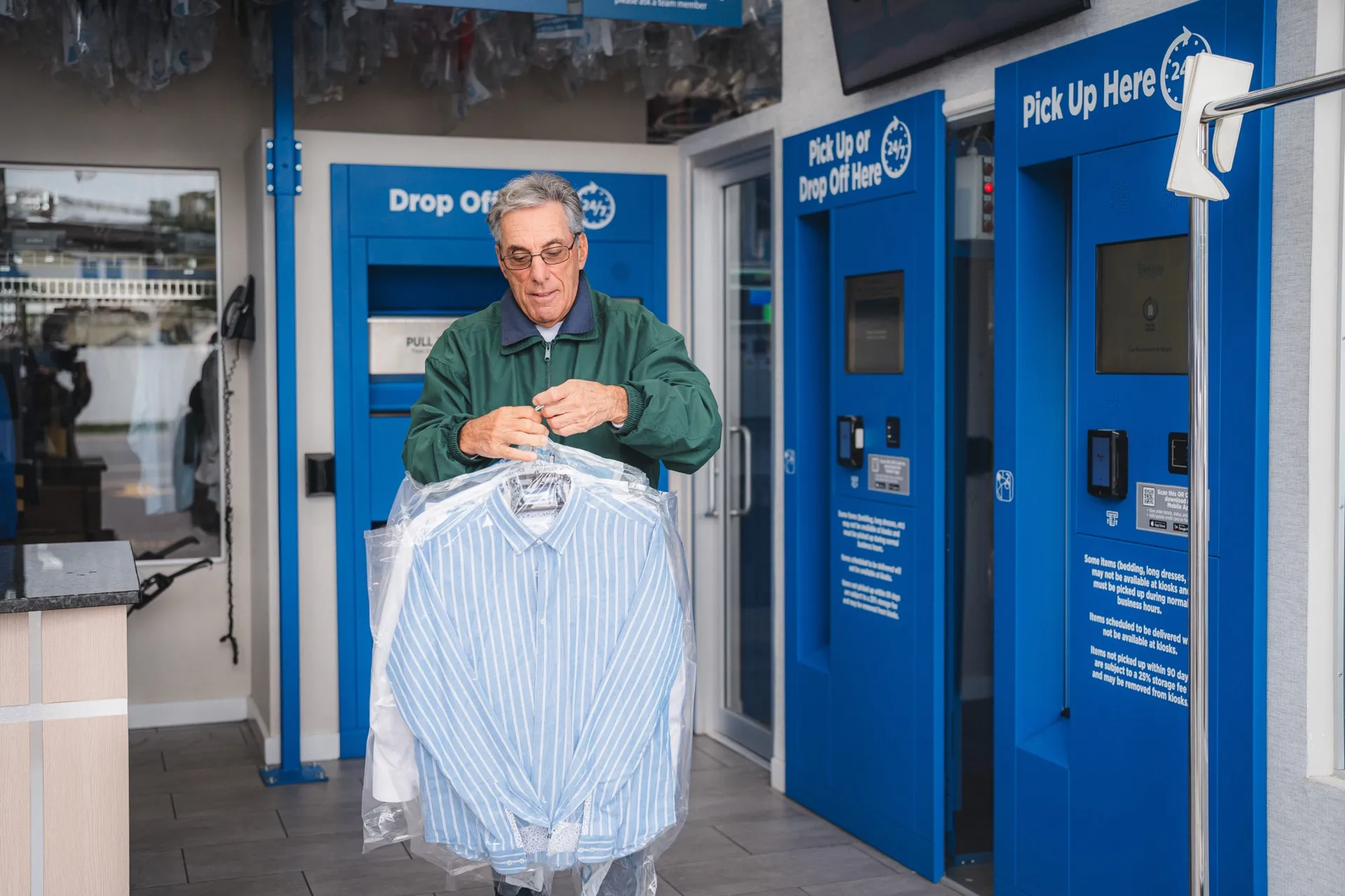 Customer holding freshly cleaned shirts picked up from the Tres Bon kiosk