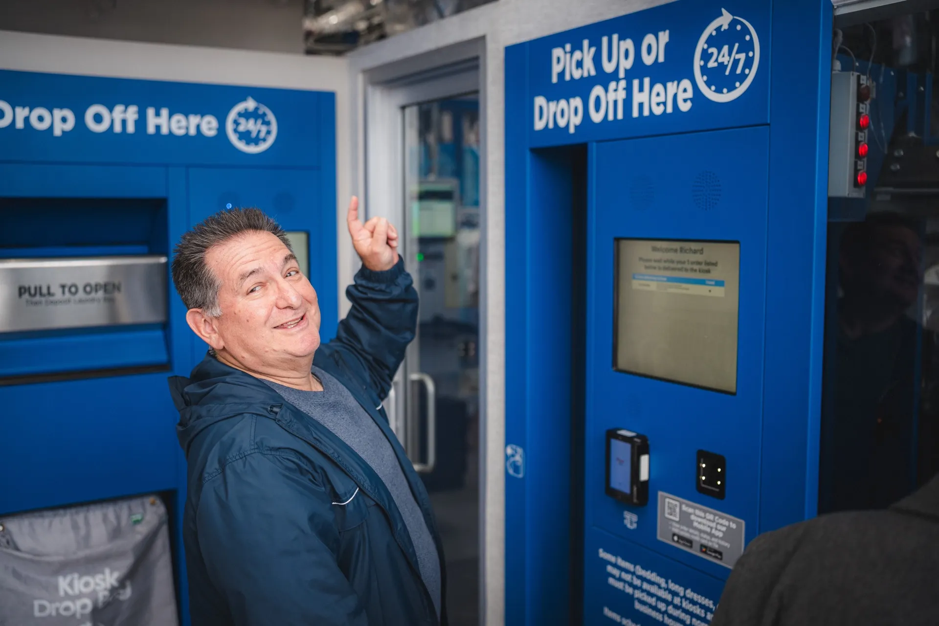 Customer pointing to the Tres Bon pick up or drop off kiosk