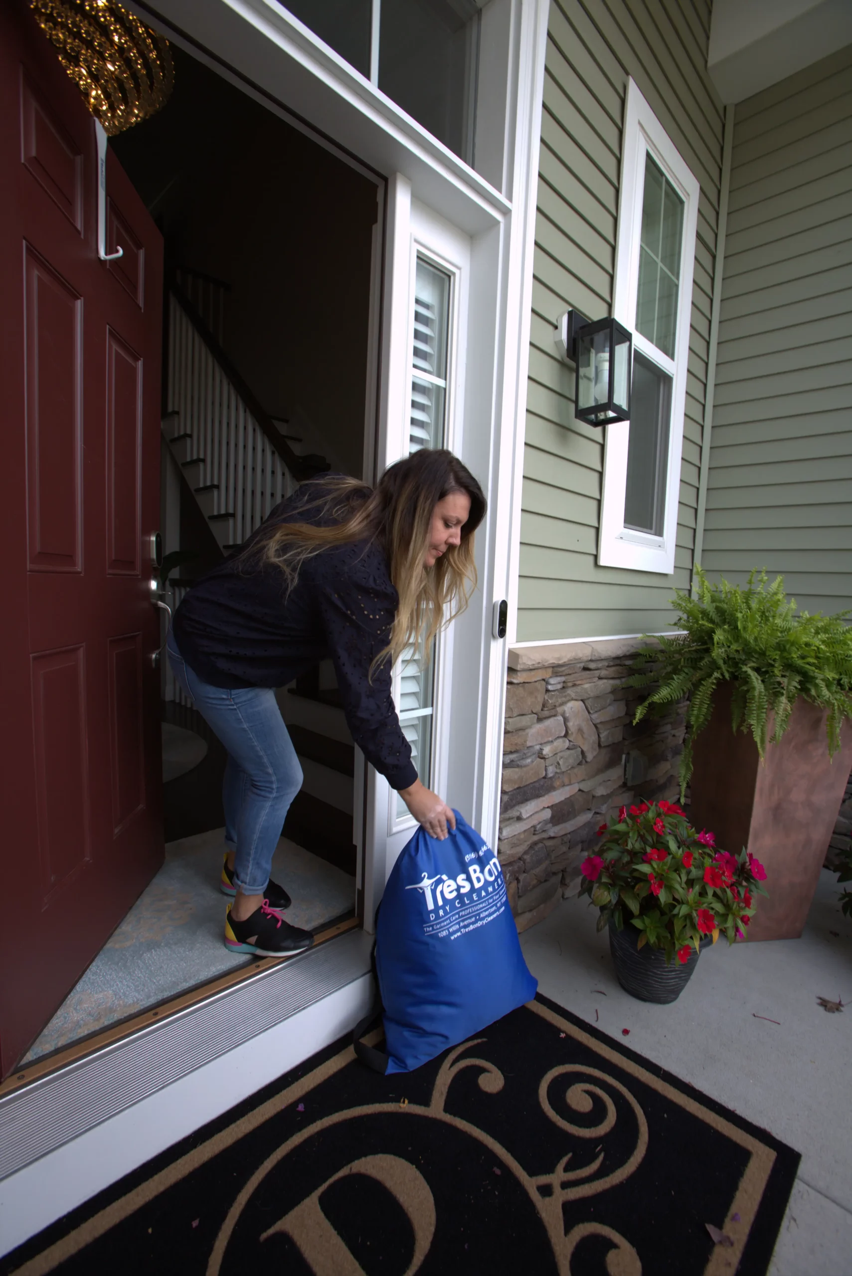 Customer picking up her Tres Bon delivery bag at the front door
